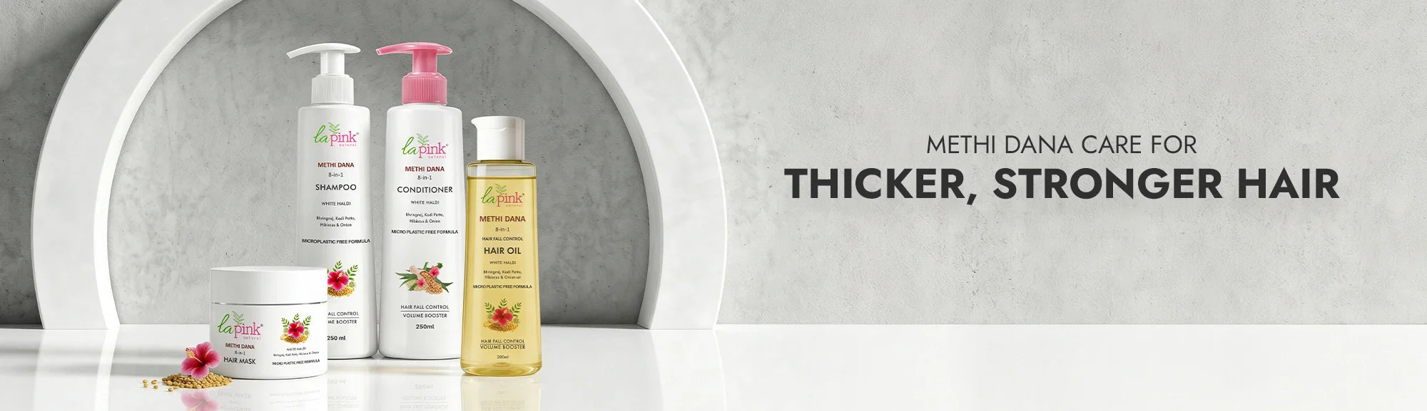 Hair care products with a mirror reflection on a gray background, promoting thicker and stronger hair.