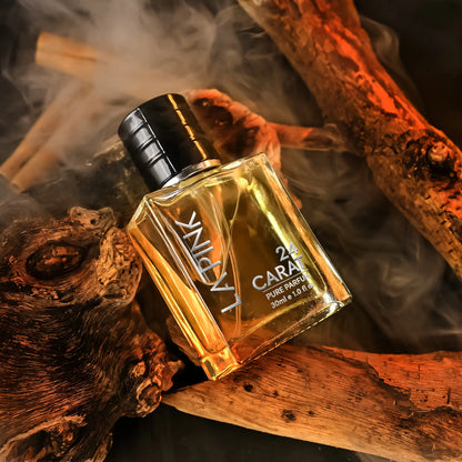 A bottle of LAPINCK 24 CARATS Pure Essence perfume with golden amber liquid, resting on rustic wood pieces with a smoky background.

