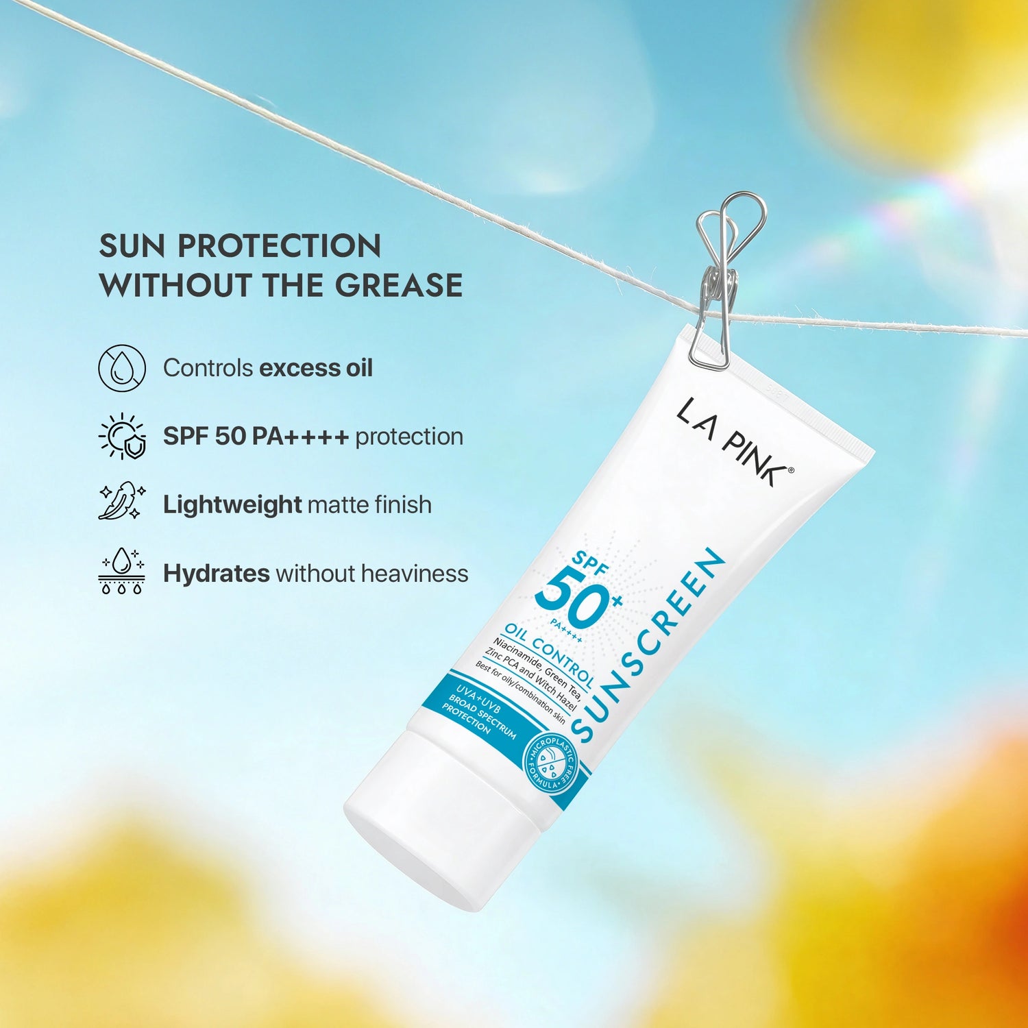 LA Pink sunscreen tube with sun protection benefits on a blurred outdoor background