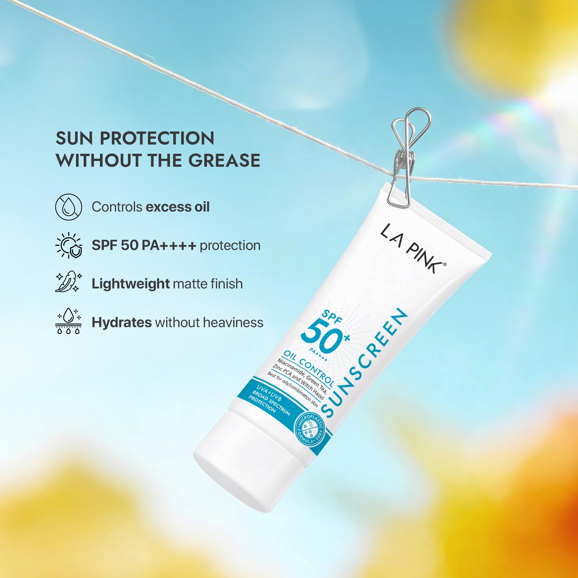 LA Pink sunscreen tube with sun protection benefits on a blurred outdoor background