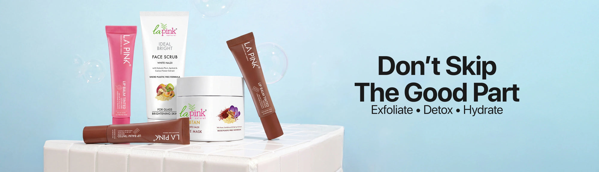 Skincare products on a white surface with a blue background and text promoting exfoliation, detox, and hydration.