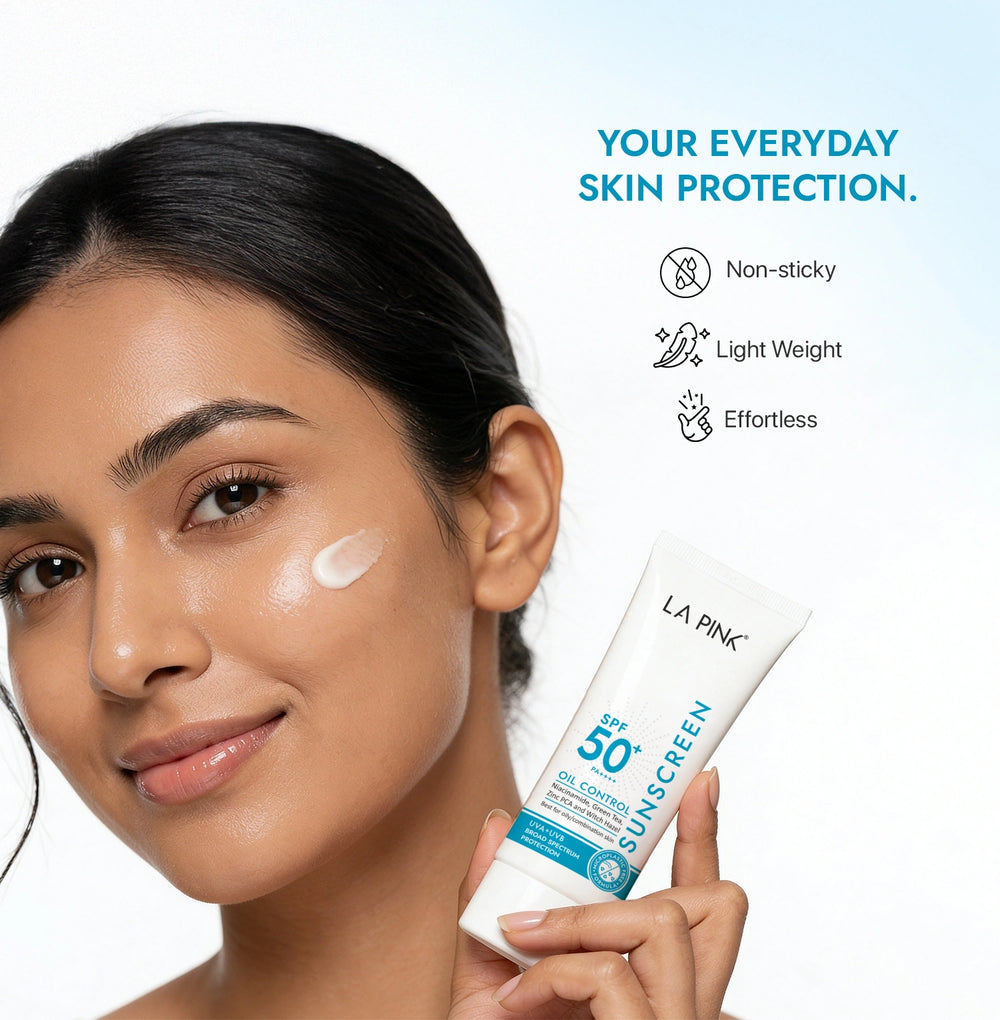 Woman applying sunscreen with a bottle labeled 'La Pink' on a light blue background