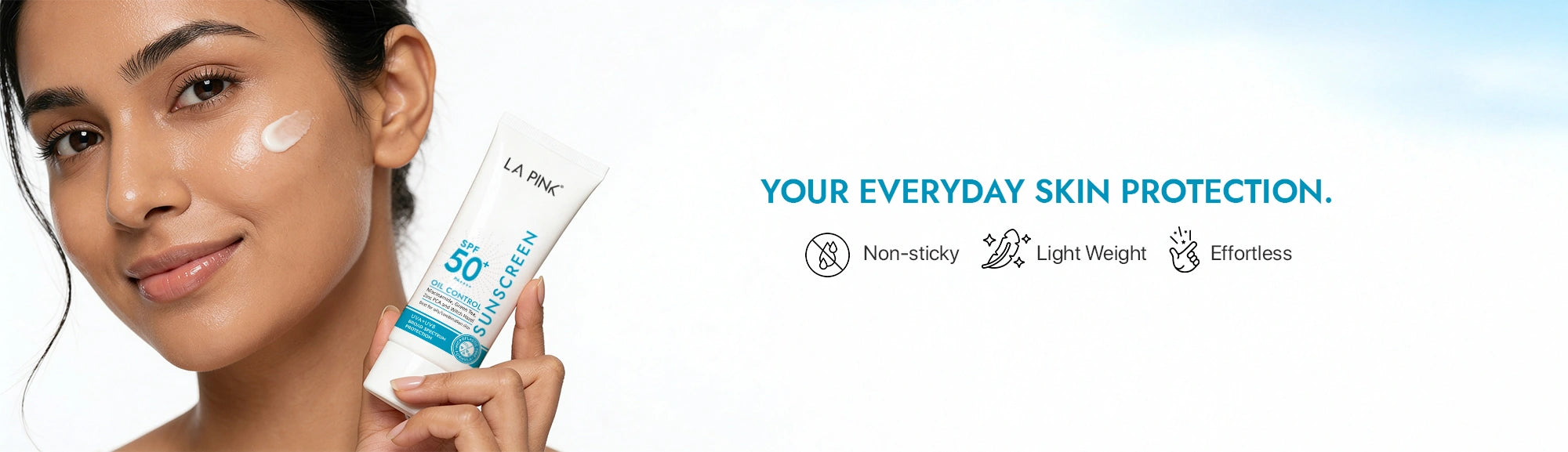 Woman holding sunscreen with product details on a light blue gradient background