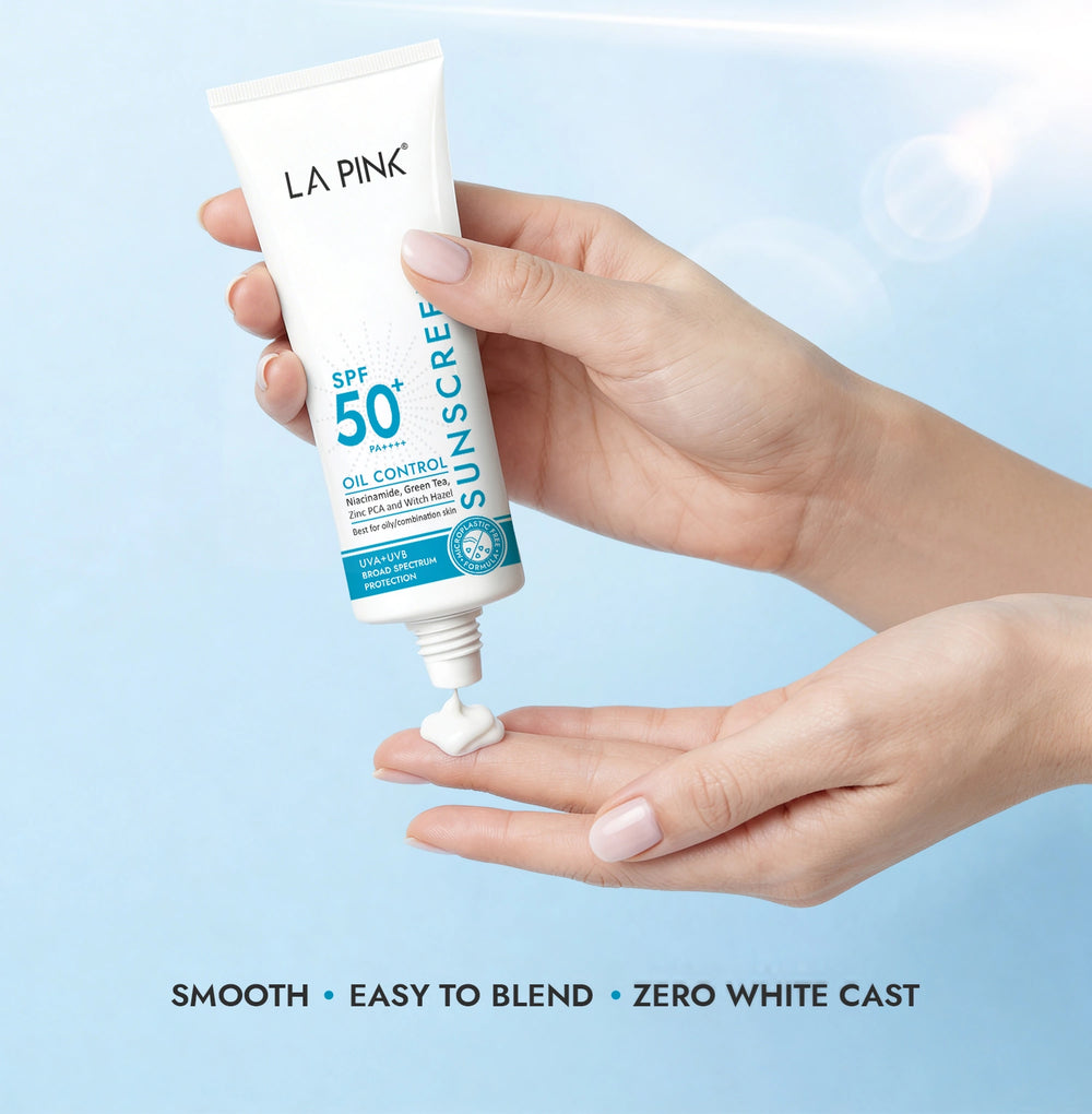 Hand holding a tube of La Pink sunscreen with a blue background