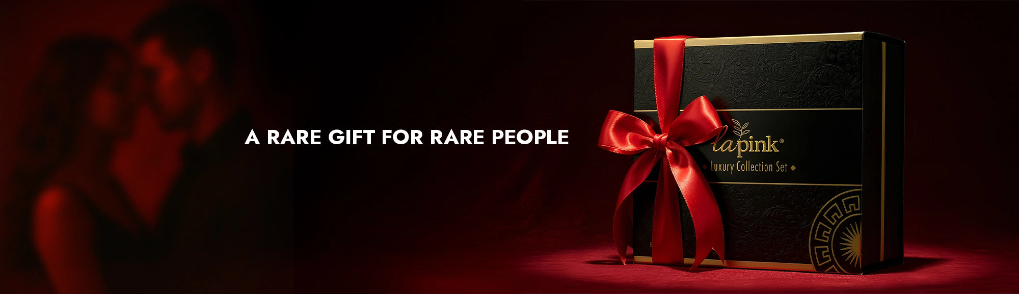 Gift box with a red ribbon on a dark background, featuring the brand 'La Perla'.
