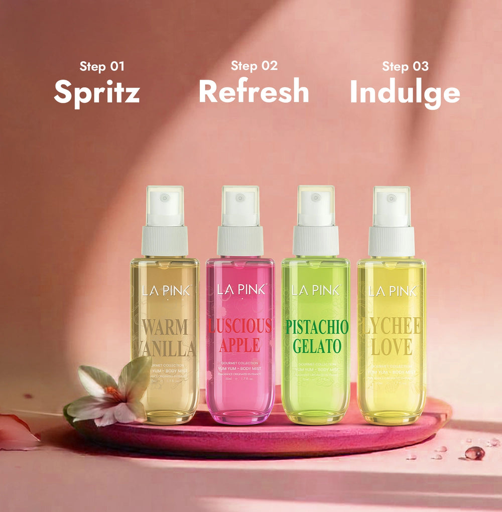 Four bottles of 'LA Pink' scented products on a pink tray with a soft pink background.