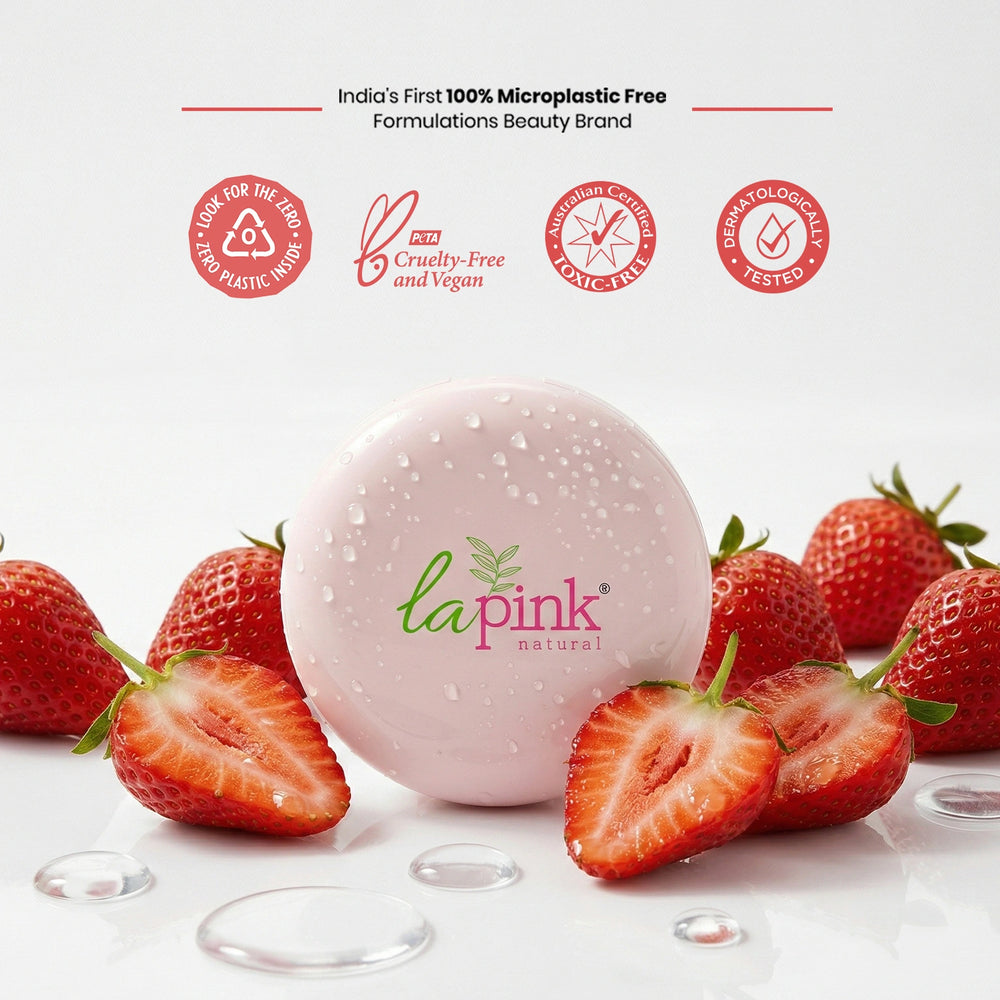Pink bath bomb with 'la pink natural' branding surrounded by strawberries on a white background