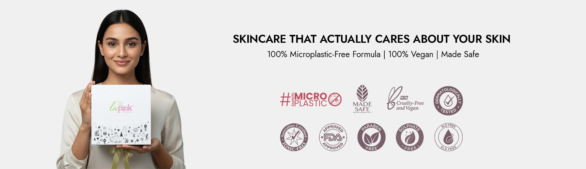 Woman holding a skincare product box with brand logos and text on a white background