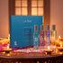 LA PINK Silver Collection perfume gift set featuring a blue box and four individual bottles with silver caps, displayed on a decorated table with lit candles and warm ambient lighting.


