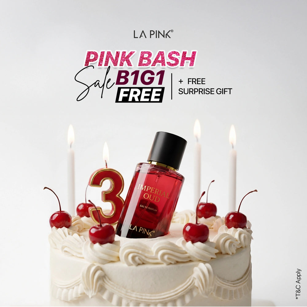 Cake with a bottle of perfume, candles, and cherries on top, featuring LA Pink branding.