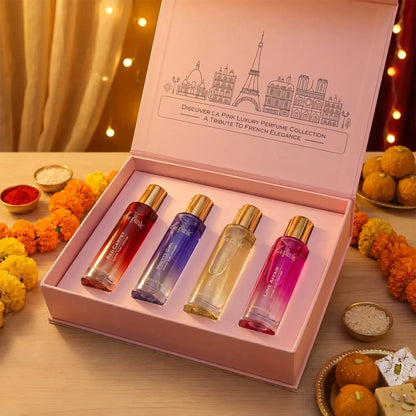 LA PINK body mist set in a colorful box with four different scents: Aqua Pell, Pure Love, Dream Romance, and Wild Secret. The set is styled on a beige surface with decorative dried flowers, pearls, and gift boxes in the background.

